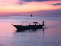 A banka drops anchor in the purple evening sea.