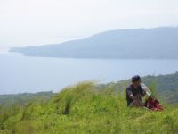 The eastern tip of Maricaban Island across the Maricaban Channel. The channel connects Balayan Bay with the smaller Batangas Bay. The small island in the mist behind Maricaban is Bonito Island.