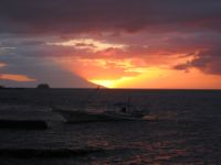 By winter solstice, as in this picture, the sun sinks in its leftmost position (as seen from Anilao) behind Mount Kalawite, the northmost tip of Mindoro. As winter turns into summer the sunset turns right, and by mid summer the sun sets east of Calatagan's Cape Santiago.